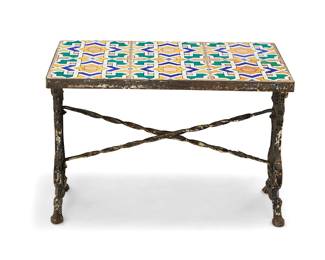 1097 A tile top cast iron low table 20th century With Moorish/Spanish Revival geometric pattern glazed ceramic tiles raised on a painted iron base with scroll supports Height 17 1/8 in., width 25 1/2 in., depth 16 1/2 in. Estimate: $300 - $500