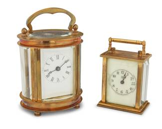 1309 Two brass carriage clocks Early 20th century One marked: Waterbury Clock Co. / U.S.A Each glazed case with handle and enameled metal dial, comprising one diminutive Waterbury Clock Co. bearing Arabic numerals, and another bearing Roman numerals 2 pieces Larger height with handle 4 1/4 in., width 2 3/4 in., depth 2 1/4 in.; smaller height with handle 3 in., width 2 in., depth 1 3/8 in. Estimate: $150 - $250