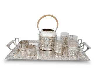 1116 Emanuel Josef Margold (1888-1962) A Wiener Werkstätte silver plated part tea service for Wolkenstein & Glückselig, early 20th century Each marked: W & G; tray further marked: [flag] [indecipherable] / Garantie; each associated marked: YUMET1COPT Comprising a hot water kettle, two-handled tray, and four teacups with glass liners, together with two Russian silver-plated teacup holders 8 pieces Tray height 2 1/8 in., width 23 in., depth 13 1/4 in.; kettle height 10 3/8 in., width 9 1/2 in., depth 5 5/8 in. Estimate: $400 - $600