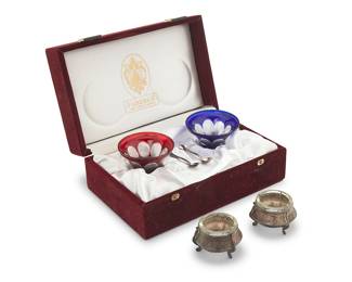 1184 A pair of Fabergé overlay glass open salt cellars Late 20th century Each glass etched: Faberge; each spoon unmarked, XRF tested for sterling; associated holders marked: [SYUMET] / [indecipherable] 30K With two sterling silver spoons, in original fitted box, together with a pair of Russian silver-plated and glass open salt cellars 6 pieces Each glass height 2 in., diameter 2 3/4 in.; height of box 3 7/8 in., width 8 5/8 in., depth 5 3/4 in. Total weighable sterling 0.2 oz. troy approximately Estimate: $150 - $250