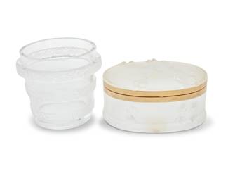 1037 A Lalique glass 'Riquewihr' vase and 'Coppelia' vanity box Mid/late 20th century Vase etched: Lalique France; box etched: Lalique ® France; and with applied label: BOITE COPPELIA / 10578 / MADE IN FRANCE 2 pieces Vase height 4 7/8 in., diameter 5 5/8 in.; box height 3 3/4 in., width 7 1/8 in., depth 5 1/2 in. Estimate: $400 - $600