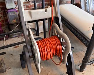 Two-wheeled plastic hose reel cart with electrical cord