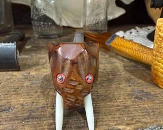 Carved figural pipe with tusks and red eyes