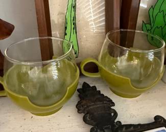 Pair of green glass cups with holders
