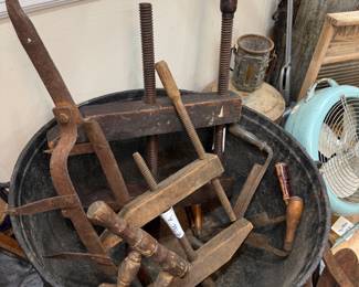 Cast iron cauldron of antique wood clamps and tools