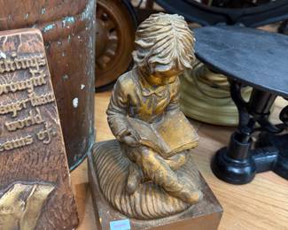 Gilt figurine of child reading on wood base