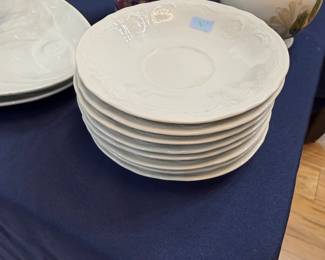 Stack of white embossed porcelain saucers