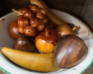 Bowl of carved wooden fruit in enamelware bowl