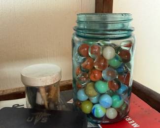 Blue mason jar of vintage marbles with US first aid tin