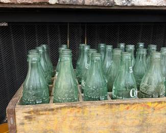 Wooden Coca-Cola crate of vintage green glass bottles