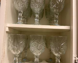Set of pressed glass goblets in cabinet