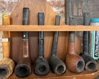 Six estate smoking pipes in wooden rack