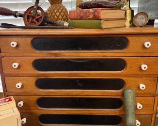 Antique oak spool cabinet with brass and cast iron toy cannon