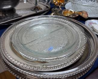 Stack of silverplate round trays and divided glass dish