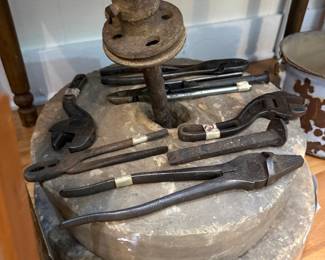 Vintage pliers and wrenches on antique millstone