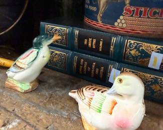 Pair of ceramic duck figurines with leather bound books