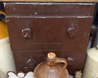 Antique metal trunk with stoneware whiskey jug