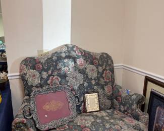 Floral upholstered camelback settee with carved feet