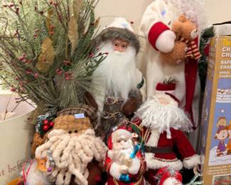 Collection of Santa Claus figures and holiday greenery