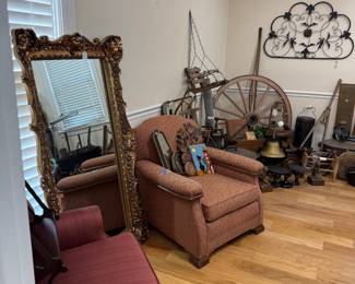 Ornate gilt floor mirror and upholstered armchair