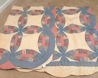 Double Wedding Ring quilt featuring scalloped edges and multi-colored calico floral prints with solid blue and pink accents