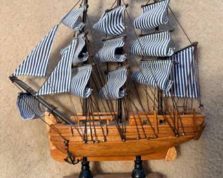 handcrafted wooden Heritage Mint H.M.S. Bounty model ship features distinctive blue-and-white striped cloth sails and a British Union Jack flag