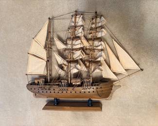 handcrafted wooden tall-ship model (resembling a historical frigate or man-of-war like the USS Constitution), mounted on a rectangular wooden display base with turned stanchions