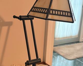 Tiffany-style adjustable swing-arm desk and task lamp featuring a bronze-finish metal base and an off-white stained art glass shade with geometric filigree trim