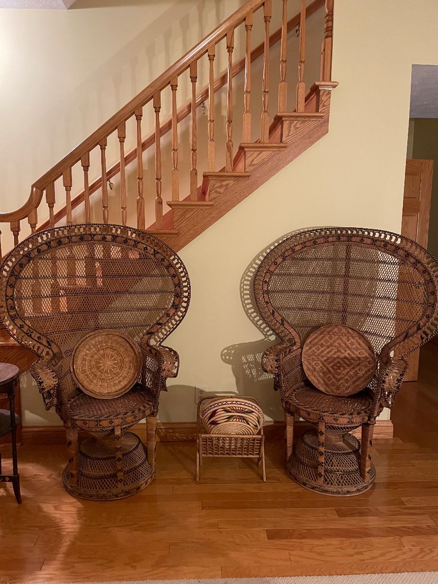 vintage mid-20th-century wicker and rattan Emmanuelle peacock chair features a dramatic flared fan back and an intricate hourglass pedestal base