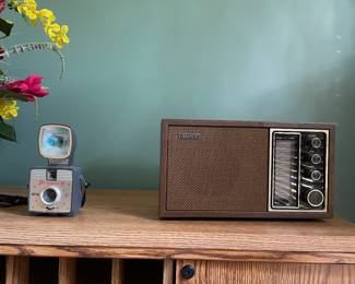 vintage 1970s Sony TFM-9440W AM/FM Tabletop Radio featuring a classic wood grain cabinet and an analog tuning dial. Camera is a Vintage Imperial Satellite II 127-format box camera made by the Herbert George Company in Chicago during the late 1950s.