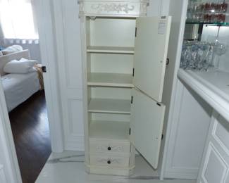 Tall storage cabinet with ornate trim