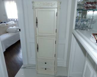 Tall storage cabinet with ornate trim