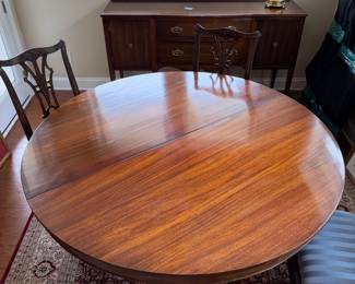 B41 - $950. Round Wooden Dining Table with 8 Chairs. Table is 5' round x 29.5" tall. Floor to bottom of table lip is 25.5".  Table has 3 leaves. 2 - 18" leaves. 1 - 13" leaf. Includes table pads for all. Overall very good vintage condition, a few surface marks not deep gouges. Chairs are all sturdy with varying wear on cushions and wood.  