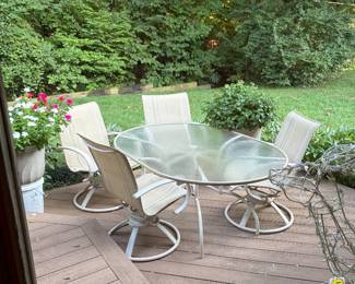 Outdoor furniture, glass top table and four swivel chairs