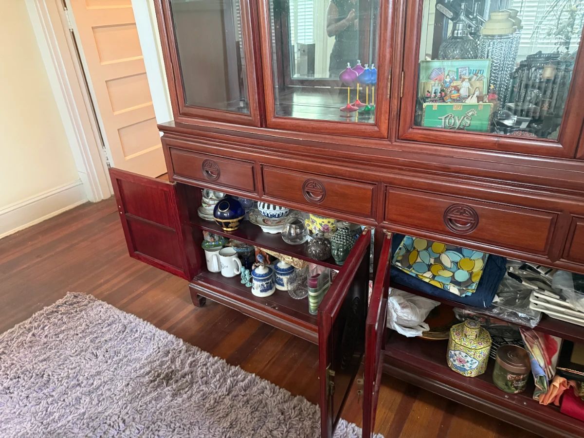 Antique wood china cabinet with glass display doors, collectibles, and dishware