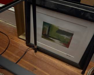 Framed watercolor print with double matting on wooden display shelf