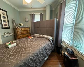 Bedroom set with queen bed, matching nightstands, framed artwork, and table lamp