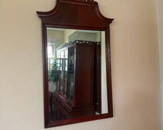 Antique wall mirror with carved wood pediment and ornate frame