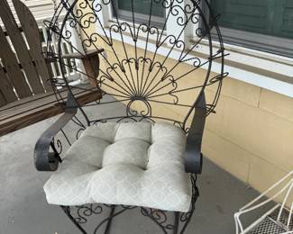 Wrought iron patio loveseat with cushions on covered front porch