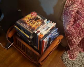 Collection of DVDs, VHS tapes, and books on vintage wooden shelf