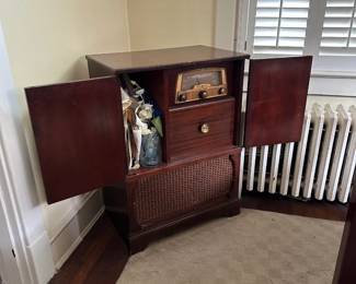 Vintage wood nightstand with wicker drawer accent and cast iron radiator