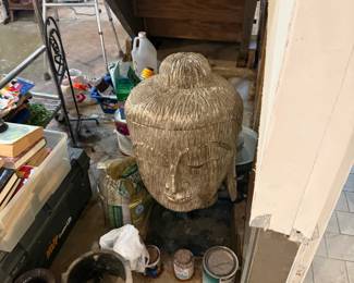 Garage storage area with wicker baskets, paint cans, and cleaning supplies