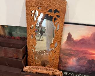 Carved wooden decorative mirror frame with cutout design and framed church print