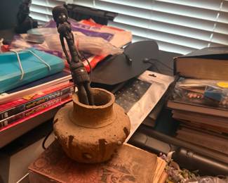 Desk area with wooden bowl, books, papers, and assorted household items