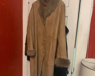 Vintage fur coat with dark fur collar on hanger in closet