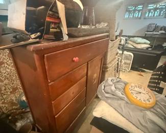 Assorted bags, electronics, and storage items on wooden dresser