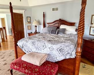 traditional wooden four-poster bed featuring prominent barley-twist carved posts and an arched headboard