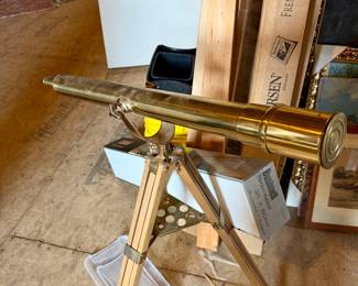 vintage Bushnell Harbormaster brass telescope mounted on a wooden tripod stand