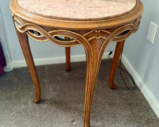 vintage French Provincial or Hollywood Regency-style round side table featuring a pink marble top and carved cabriole legs with gold-leaf accents