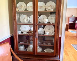 wooden china cabinet featuring glass-front doors and lower storage drawers